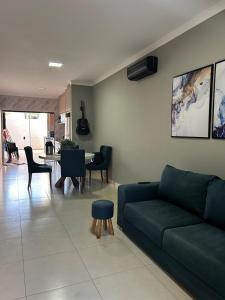 een woonkamer met een groene bank en een tafel bij Casa aconchegante em local Estratégico in Foz do Iguaçu