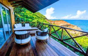 Un balcón con sillas y vista al mar. en Turtle Beach villa, Private beach, en Woodford Hill
