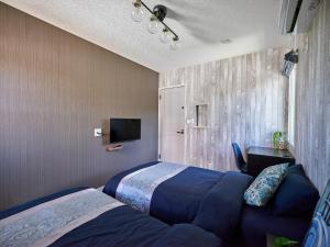 a bedroom with two beds and a tv on the wall at VOGUE C, a private inn with a panoramic view of th - Vacation STAY 14693v in Isumi