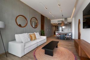 a living room with a white couch and a table at El Cielo Sayulita in Sayulita