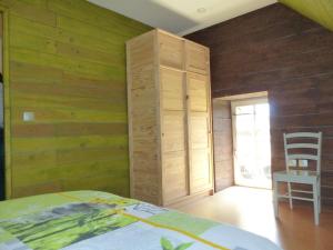 Un dormitorio con paredes de madera y una cama y una silla. en Maison éco-gite entièrement rénovée avec WIFI et espace bien-être - FR-1-489-290, en Bransat 3 fotos más