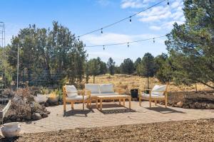 a patio with a wooden table and two chairs at Scenic Grand Canyon Hideaway 2BD Superhost in Williams
