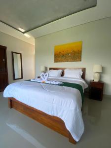 a bedroom with a large bed with a bow on it at Gunung Homestay Bali in Tabanan