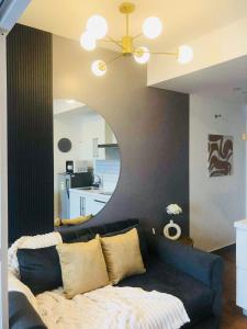 a living room with a blue couch and a mirror at Acqua Private Residences Livingstone Tower in Sampong