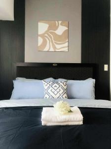 a bed with a white towel on top of it at Acqua Private Residences Livingstone Tower in Sampong