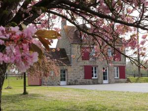 Ménil-GondouinにあるMaison normande rénovée avec grand jardin, idéale pour famille, proche lac et randonnées - FR-1-497-143のピンクの花が目の前に咲く石造りの建物