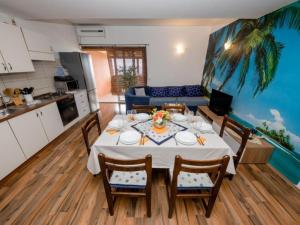 a kitchen and a dining room with a table and chairs at Apartments Scerbe Gordana & Miljenko Rab - Three Bedroom Apartment with Terrace 2 in Otok Rab