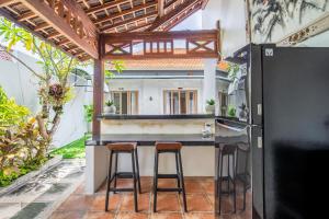 a kitchen with two stools at a kitchen counter at Ammara Viila Jimbaran in Nusa Dua