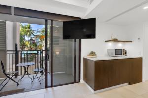 una cucina con balcone, tavolo e forno a microonde di Lagoon Hideaway - Swim out Nook at Temple Resort a Craiglie