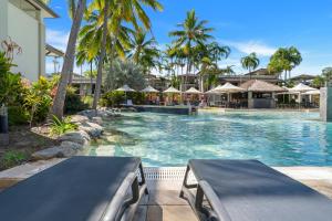 una piscina in un resort con palme e ombrelloni di Lagoon Hideaway - Swim out Nook at Temple Resort a Craiglie