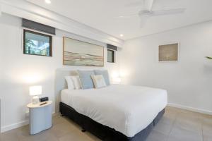 una camera con un grande letto bianco e due lampade di Lagoon Hideaway - Swim out Nook at Temple Resort a Craiglie