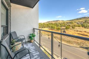 balcón con sillas y vistas a la carretera en Vita Resort Vernon - Modern Studio on Okanagan Lake, en Vernon