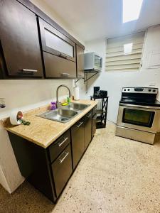 a kitchen with a sink and a stove at 3 Bedroom Home Best Price Bayamon by Rentalspr in Bayamon +8 photos