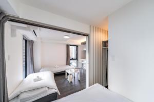 a bedroom with two beds and a mirror at 大阪難波リバーサイドガーデンホテルOsaka Namba River Side Garden Hotel in Osaka