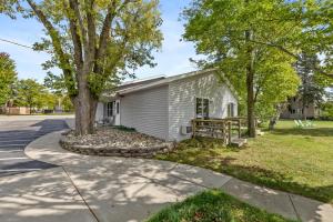 a white house with a tree and a sidewalk at Double Bed Suite with Full Kitchen in Lake City