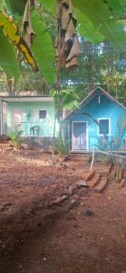 a blue house in the middle of a forest at green Garden Resort in Canacona