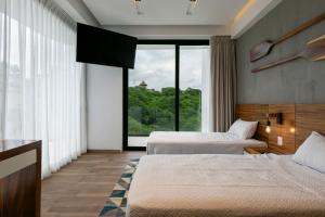 a hotel room with two beds and a large window at El Cielo Sayulita in Sayulita +35 photos