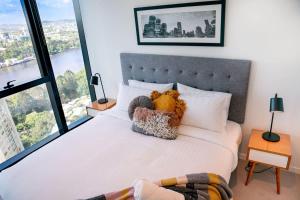 a bedroom with a bed with teddy bears on it at Lvl30 Garden/River views Balcony by Stylish Stays in Brisbane