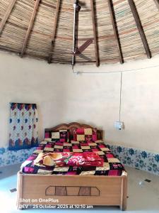 a bedroom with a bed with a wooden frame at Ranfamily home stay in Dhordo