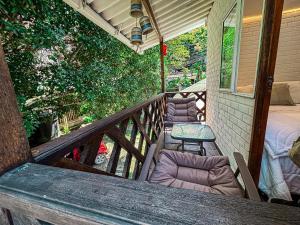 a porch with two chairs and a table on it at Cabañas betania in Santa Marta