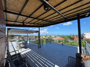 d'une terrasse avec un toit et une table et des chaises. dans l'établissement Brand new Luxury Pool Villa Seaview Rooftop, à Ban Saiyuan (1)