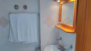 baño con cortina de ducha blanca y lavamanos en Posidonia Pension, en Amarinto