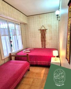 Un dormitorio con dos camas y una cruz en la pared. en Casa ideal familias-8 personas a 3 cuadras del mar, en Monte Hermoso