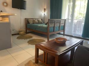 a living room with a couch and a table at Appartement Papeete-Airport, Parking, wifi,AC,Pool in Papeete