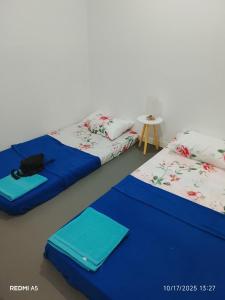 two beds sitting next to each other in a room at Homestay Akinabalu Kinarut in Papar