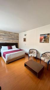 Un dormitorio con una cama grande y dos sillas. en Hotel Juliette Bogota Chapinero, en Bogotá