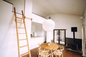 une pièce avec une table en bois et une échelle dans l'établissement Suu -瀬戸内の小さな別邸, à Futami