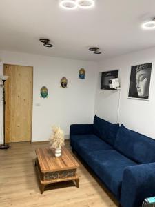 a living room with a blue couch and a coffee table at Badash Tiny Village in Polovragi