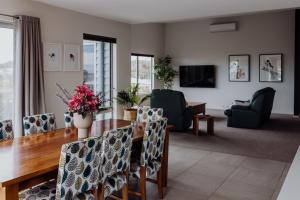 a living room with a dining room table and chairs at Bicheno Gardens in Bicheno