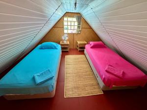 a room with two beds in a tent at Marū Beach House in Afareaitu