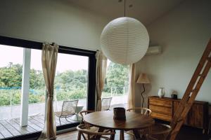 une pièce avec une table et des chaises et une grande fenêtre dans l'établissement Suu -瀬戸内の小さな別邸, à Futami