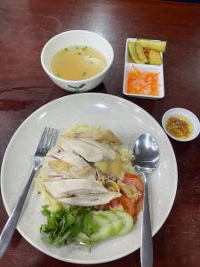 a plate of food with chicken and vegetables and a bowl of soup at Joes Homestay in Siem Reap +10 photos