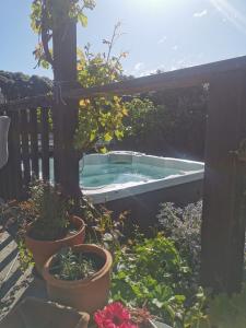 a hot tub in a garden with potted plants at Apartment style Beach House. Birdlings Flat in Little River