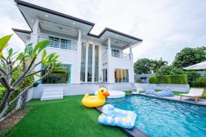 a house with a rubber duck in front of a swimming pool at Tidal Coast Villa Pattaya in Ban Huai Yai