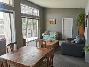 a living room with a table and a couch at Apartment style Beach House. Birdlings Flat in Little River