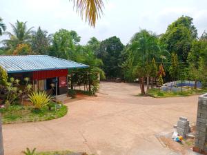 ein Gebäude mit blauem Dach neben einem Parkplatz in der Unterkunft Kamath regency and cottages in Dharmastala