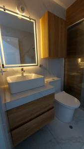 Un baño con lavabo, inodoro y espejo. en Luxury apartment, en Trujillo
