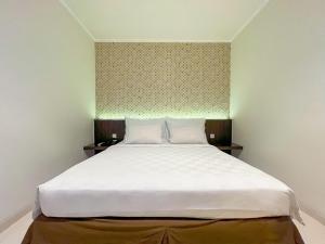 um quarto com uma grande cama branca em um quarto em Hotel 88 Embong Kenongo - Kayun By WH em Surabaia