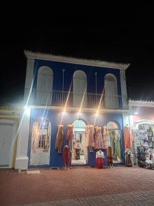a blue building with clothes on display in front of it at Colonial House in Porto Seguro