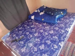 a bed with a purple comforter and pillows on it at Green moon Home stay 