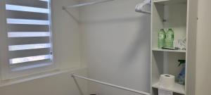 a bathroom with a window and a shelf with bottles at Single Court in Abbotsford