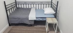 a small bed in a room with a table at Single Court in Abbotsford