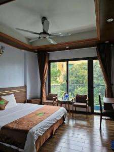 a bedroom with a bed and a ceiling fan at Khách sạn Rosalia in Tam Ðảo