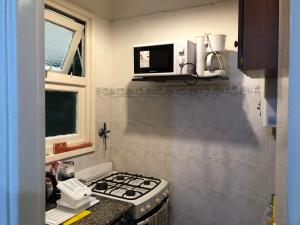 a small kitchen with a stove and a microwave at Departamento Adrián in Mar del Plata +10 photos