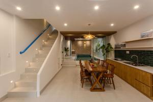 a kitchen and dining room with a table and stairs at LG Villa My Khe Beach in Da Nang