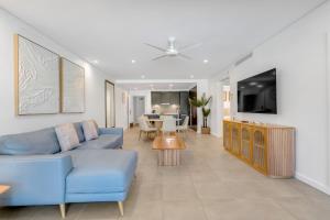 un soggiorno con un divano blu e un tavolo di Infinity's Edge - Poolside Retreat at Temple Resort a Craiglie